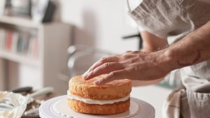 A Baker Assembling a Cake