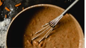 A Whisk and Batter in a Bowl