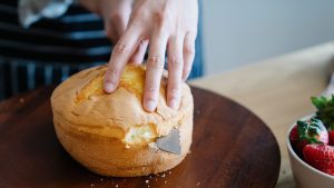 Close-Up Shot of a Person Slicing a Cake