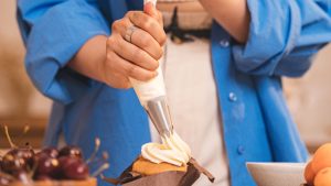 Close up of Putting Whipped Cream on Cake