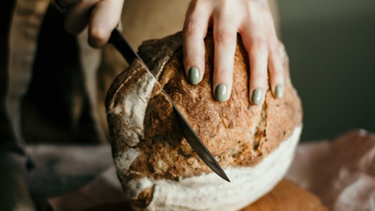 Crop cook cutting bread on table