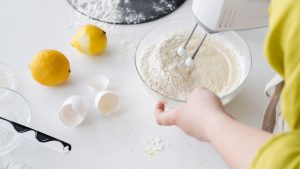 Crop woman mixing cake dough