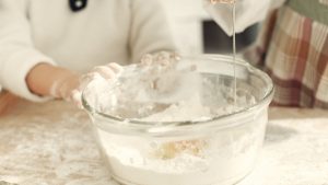 Daughter and Parent Making Cake Batter.-