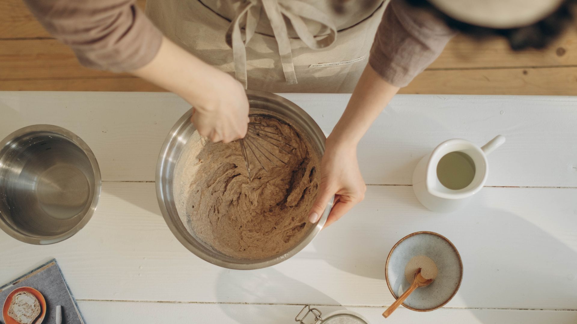 Person Holding Silver Mixing Bowl with Brown Batter