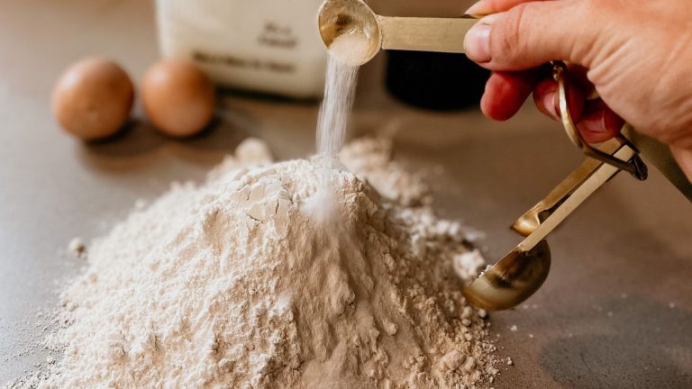 Person Pouring White Powder on White Powder