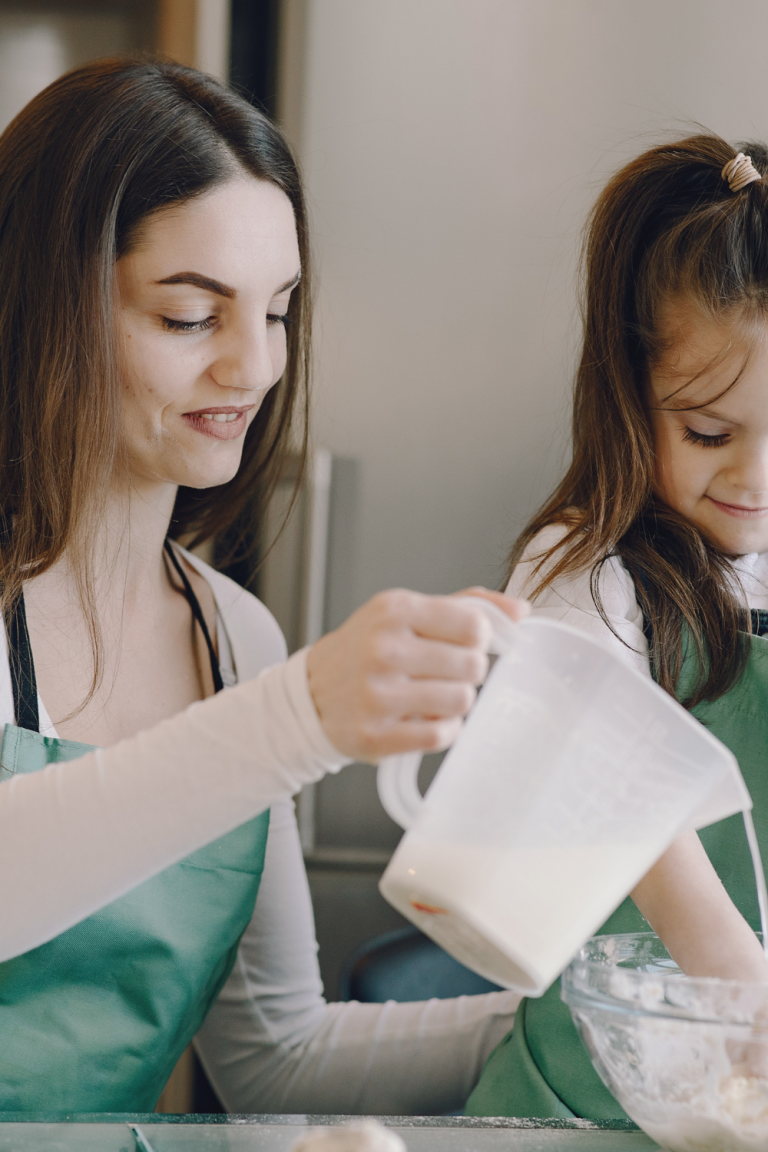 Photo of Woman and Child Smiling While Baking