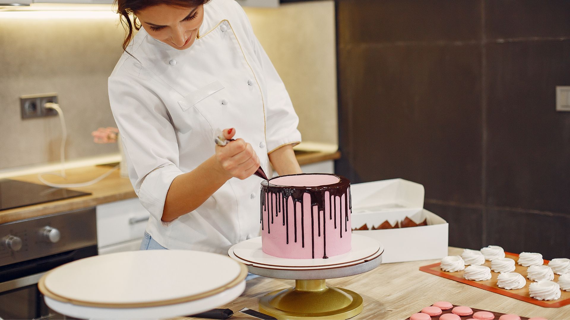 Smiling young woman squeezing chocolate from pastry bag on cake in pastry store