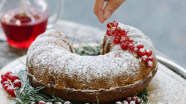 Woman decorating Christmas cake with redcurrant