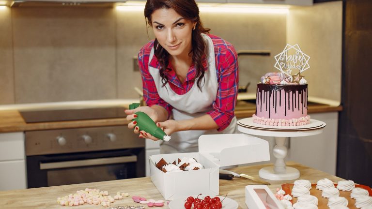 Woman in Red Checked Shirt Icing a Cake