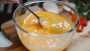 Woman mixing ingredients for breakfast in kitchen