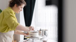 Woman preparing cake in kitchen